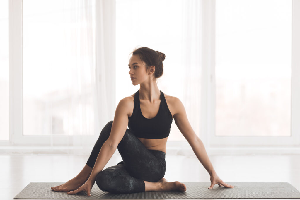 Fit girl practicing yoga looking at copy space